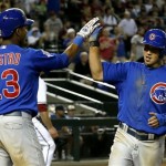 Chicago Cubs' Darwin Barney, right, gets a high-five from teammate Starlin Castro, left, after Barney scores a run against the Arizona Diamondbacks in the ninth inning of a baseball game on Monday, July 22, 2013, in Phoenix. The Cubs defeated the Diamondbacks 4-2. (AP Photo/Ross D. Franklin)