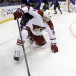 Phoenix Coyotes' Rob Klinkhammer, front, reaches for a loose puck as St. Louis Blues' Ryan Reaves defends during the first period of an NHL hockey game Tuesday, Jan. 14, 2014, in St. Louis. (AP Photo/Jeff Roberson)