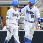 UCLA's Cody Regis (18) celebrates his run with teammate Eric Filia in the fourth inning of Game 2 in their NCAA College World Series baseball finals against Mississippi State, Tuesday, June 25, 2013, in Omaha, Neb. (AP Photo/Eric Francis)