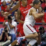  Arizona's Nick Johnson, center, hangs on to the ball as he drives to the basket against the defense of Texas Tech's Robert Turner, in the second half of an NCAA college basketball game on Tuesday, Dec. 3, 2013, in Tucson, Ariz. (AP Photo/John MIller)