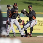 San Francisco Giants' Marco Scutaro, right, throws after Brandon Crawford, left, tosses Scutaro the ball during a spring training baseball workout Saturday, Feb. 16, 2013, in Scottsdale, Ariz. (AP Photo/Darron Cummings)
