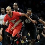 Brooklyn Nets' Joe Johnson, right, and Andray Blatche, center, pursue Chicago Bulls' Taj Gibson during the first half of the NBA basketball game at the Barclays Center Wednesday, Dec. 25, 2013, in New York. (AP Photo/Seth Wenig)