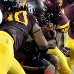 Utah running back John White IV, center, is sandwiched between Arizona State defensive tackle Will Sutton, left, and linebacker Steffon Martin, right, in the second quarter of an NCAA college football game, Saturday, Sept. 22, 2012, in Tempe, Ariz. (AP Photo/Paul Connors)

