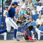 Toronto Blue Jays starting pitcher R.A. Dickey, left, runs to the plate after throwing a wild pitch in the dirt as Boston Red Sox's Jackie Bradley Jr., right, scores a run during the first inning of their exhibition spring training baseball game, Monday, Feb. 25, 2013, in Dunedin, Fla. (AP Photo/The Canadian Press, Nathan Denette)