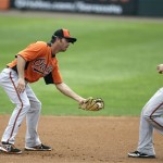 Baltimore Orioles shortstop J.J. Hardy, left, looks to tag out teammate Jason Pridie at second base during a baseball spring training intra squad game Thursday, Feb. 21, 2013, in Sarasota, Fla. (AP Photo/Charlie Neibergall)