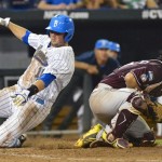 
UCLA's Cody Regis, left, slides safely to home plate on a single by Eric Filia ahead of the throw to Mississippi State catcher Nick Ammirati in the sixth inning of Game 2 in their NCAA College World Series baseball finals, Tuesday, June 25, 2013, in Omaha, Neb. (AP Photo/Ted Kirk)