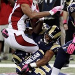 Arizona Cardinals wide receiver Larry Fitzgerald is stopped by St. Louis Rams cornerbacks Cortland Finnegan (31) and Bradley Fletcher (32) after catching a pass during the first quarter of an NFL football game, Thursday, Oct. 4, 2012, in St. Louis. (AP Photo/Seth Perlman)