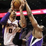Phoenix Suns' Michael Beasley (0) gets stopped in the lane as Sacramento Kings' Jason Thompson defends during the second half in a preseason NBA basketball game, Monday, Oct. 22, 2012, in Phoenix. The Suns won 103-88. (AP Photo/Ross D. Franklin)