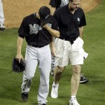 Florida Marlins pitcher Clay Hensley, left, hangs his head as he leaves the game after injuring himself against the Arizona Diamondbacks during the ninth inning of a baseball game, Wednesday, June 1, 2011, in Phoenix. (AP Photo/Matt York)