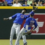 Chicago Cubs' Junior Lake, left, catches a fly-out by Arizona Diamondbacks' Jason Kubel as teammate Starlin Castro (13) backs off during the fifth inning of a baseball game on Wednesday, July 24, 2013, in Phoenix. (AP Photo/Matt York)