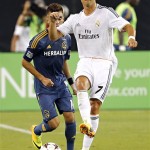 Real Madrid forward Cristiano Ronaldo (7) moves the ball upfield in front of Los Angeles Galaxy's Hector Jimenez defends during the first half of the International Champions Cup soccer match, Thursday, Aug. 1, 2013, in Glendale, Ariz. (AP Photo/Matt York)