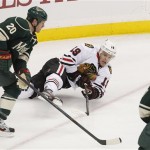 Chicago Blackhawks' Jonathan Toews (19) shoots as he falls in front of Minnesota Wild's Ryan Sutter (20) in the first period of Game 3 of a forst-round NHL hockey Stanley Cup playoff series Sunday, May 5, 2013 in St. Paul, Minn. Minnesota defeated the Blackhawks 3-2 on overtime.(AP Photo/Andy King)