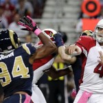 Arizona Cardinals quarterback Kevin Kolb, right, throws as St. Louis Rams defensive end Robert Quinn (94) defends during the first quarter of an NFL football game, Thursday, Oct. 4, 2012, in St. Louis. (AP Photo/Seth Perlman)