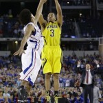 Michigan's Trey Burke (3) makes a three-point basket in the final seconds of the second half of a regional semifinal game against Kansas in the NCAA college basketball tournament, Friday, March 29, 2013, in Arlington, Texas. (AP Photo/David J. Phillip)