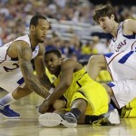 Michigan's Glenn Robinson III ,battles for a loose ball with Kansas' Travis Releford, and Jeff Withey, right, during the second half of a regional semifinal game in the NCAA college basketball tournament, Friday, March 29, 2013, in Arlington, Texas. (AP Photo/Tony Gutierrez)
