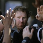 Chicago White Sox's Adam Dunn celebrates in the dugout with teammates after he scored on single by Hector Gimenez during a spring training baseball game against the Texas Rangers on Tuesday, Feb. 26, 2013, in Surprise, Ariz. (AP Photo/Charlie Riedel)