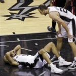 San Antonio Spurs' Manu Ginobili (20), of Argentina, checks on Tony Parker (9) who took a hard fall against the Miami Heat during the second half at Game 4 of the NBA Finals basketball series, Thursday, June 13, 2013, in San Antonio. (AP Photo/David J. Phillip)