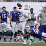 Miami Dolphins quarterback Ryan Tannehill attempts to throw a pass into the end zone as he is tackled by Buffalo Bills defensive end Mario Williams during the final seconds of an NFL football game, Sunday, Oct. 20, 2013, in Miami Gardens, Fla. The pass was incomplete and the Bills defeated the Dolphins 23-21. (AP Photo/Wilfredo Lee)