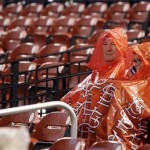 Two St. Louis Cardinals fans pass the time as they wait for the rain-delayed start of a baseball game between the St. Louis Cardinals and the Arizona Diamondbacks, Thursday, Aug. 16, 2012, in St. Louis. (AP Photo/Tom Gannam)