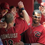 After hitting a home run, Arizona Diamondbacks' Willie Bloomquist, left, gets high-fives from teammates and a smile from Chris Young, right, during the third inning of a spring training baseball game against the Milwaukee Brewers on Wednesday, April 4, 2012, in Phoenix. (AP Photo/Ross D. Franklin)