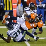 Denver Broncos' Julius Thomas (80) is tackled by Seattle Seahawks' Kam Chancellor (31) and Walter Thurmond (28) after making a reception during the second half of the NFL Super Bowl XLVIII football game Sunday, Feb. 2, 2014, in East Rutherford, N.J. (AP Photo/Bill Kostroun)