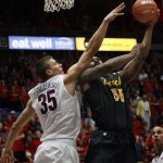 Long Beach State's Dan Jennings, right, shoots over Arizona's Kaleb Tarczewski, left, in the first half of an NCAA college basketball game, Monday, Nov. 11, 2013 in Tucson, Ariz. (AP Photo/Wily Low)