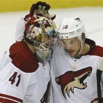 Phoenix Coyotes goalie Mike Smith (41) is congratulated by Antoine Vermette (50) after beating the Detroit Red Wings 4-2 in an NHL hockey game in Detroit, Thursday, Oct. 10, 2013. (AP Photo/Paul Sancya)