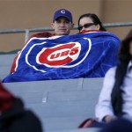 Chicago Cubs fans try to keep warm during an exhibition spring training baseball game against the San Francisco Giants Sunday, Feb. 24, 2013, in Mesa, Ariz. (AP Photo/Morry Gash)
