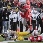 Ohio State running back Carlos Hyde, top, dives over the goal line to score a touchdown past teammate Corey Brown, right, and Iowa linebacker James Morris during the fourth quarter of an NCAA college football game Saturday, Oct. 19, 2013, in Columbus, Ohio. Ohio State beat Iowa 34-24. (AP Photo/Jay LaPrete)
