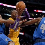 Los Angeles Lakers' Dwight Howard, center, is defended by Dallas Mavericks' Vince Carter, left, and Elton Brand in the first half of an NBA basketball game in Los Angeles, Tuesday, Oct. 30, 2012. (AP Photo/Jae C. Hong)
