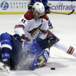 St. Louis Blues' Adam Cracknell, bottom, falls after trying to wrestle the puck away from Phoenix Coyotes' Martin Hanzal, of the Czech Republic, during the first period of an NHL hockey game Tuesday, Jan. 14, 2014, in St. Louis. (AP Photo/Jeff Roberson)