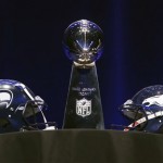  The Vince Lombardi Trophy is displayed between the Seattle Seahawks and the Denver Broncos helmets before a news conference Friday, Jan. 31, 2014, in New York. The Seahawks and the Broncos are scheduled to play in the NFL Super Bowl XLVIII football game on Sunday, Feb. 2, at MetLife Stadium in East Rutherford, N.J. (AP Photo/Charlie Riedel)