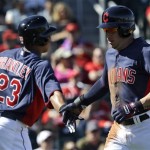 Cleveland Indians' Asdrubal Cabrera, right, is congratulated by Michael Brantley (23) after scoring on a Nick Swisher RBI single in the first inning of an exhibition spring training baseball game against the Cincinnati Reds in Goodyear, Ariz., Friday, Feb. 22, 2013. (AP Photo/Paul Sancya)