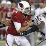 Arizona Cardinals quarterback Kevin Kolb (4) is sacked by Oakland Raiders defensive tackle Lamarr Houston (99) as another Raider closes in during the first half of a preseason NFL football game, Friday, Aug. 17, 2012, in Glendale, Ariz. (AP Photo/Rick Scuteri)