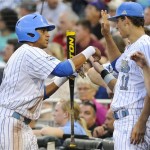 
UCLA's Kevin Williams, left, is greeted at the dugout by James Kaprielian (11) after he scored against Mississippi State on a single by Cody Regis in the fourth inning of Game 2 in their NCAA College World Series baseball finals, Tuesday, June 25, 2013, in Omaha, Neb. (AP Photo/Eric Francis)