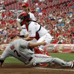 Arizona Diamondbacks' Aaron Hill, left, scores at home plate under Cincinnati Reds catcher Ryan Hanigan, right, after a double by Miguel Montero in the first inning of a baseball game, Monday, July 16, 2012, in Cincinnati. (AP Photo/David Kohl)