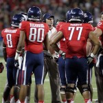 Arizona's head coach Rich Rodriguez, center, talks to his players on the sidelines during a timeout against Oklahoma State the first half of an NCAA college football game at Arizona Stadium in Tucson, Ariz., Saturday, Sept. 8, 2012. (AP Photo/John Miller)
