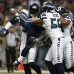 Seattle Seahawks' Chris Clemons, left, picks up St. Louis Rams running back Zac Stacy as Bobby Wagner, right, and Cliff Avril team up during the first half of an NFL football game, Monday, Oct. 28, 2013, in St. Louis. (AP Photo/Michael Conroy)