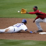 Arizona Diamondbacks' Didi Gregorius waits for a pick-off throw as Chicago Cubs' Starlin Castro dives back to second during the second inning of a spring training baseball game, Thursday, Feb. 27, 2014, in Mesa, Ariz. (AP Photo/Matt York)
