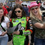  Danica Patrick, middle, signs an autograph for a fan, left, as another fan takes a selfie with Patrick before the NASCAR Sprint Cup Series auto race Sunday, March 2, 2014, in Avondale, Ariz. (AP Photo/Ross D. Franklin)