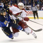St. Louis Blues right wing Chris Stewart, left, gets a shot off as he is hit by Phoenix Coyotes left wing Lauri Korpikoski during the first period of an NHL hockey game Tuesday, Jan. 14, 2014, in St. Louis. The Blues won 2-1. (AP Photo/St. Louis Post-Dispatch, Chris Lee)
