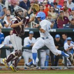 UCLA's Brian Carroll, right, scores at home plate ahead of the throw to Mississippi State catcher Nick Ammirati on a single by Eric Filia in the first inning of Game 2 in their NCAA College World Series baseball finals, Tuesday, June 25, 2013, in Omaha, Neb. (AP Photo/Ted Kirk)