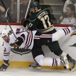 Chicago Blackhawks' Michal Rozsival (32) is taken down by Minnesota Wild's Torrey Mitchell in the third period of ame 3 of an NHL hockey Stanley Cup playoff series Sunday, May 5, 2013 in St. Paul, Minn. Minnesota defeated the Blackhawks 3-2 on overtime.(AP Photo/Andy King)