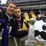 Sam Muffoletto, 21, and Phil Luzi, 21, hold up signs and a home-made Super Bowl trophy as they wait for the start of Baltimore's celebration for the Super Bowl champion Baltimore Ravens at Ravens stadium on Tuesday, Feb. 5, 2013. Officials expect about 100,000 people to attend the events. (AP Photo/Alex Dominguez)