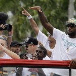 NBA champion Miami Heat's LeBron James, right, waves to the fans during the celebration parade in Miami, Monday, June 24, 2013. (AP Photo/Alan Diaz)