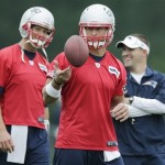 New England Patriots quarterback Tim Tebow, center, tosses the ball as Tom Brady, left, talks with offensive coordinator Josh McDaniels during a team football practice in Foxborough, Mass., Tuesday June 11, 2013. (AP Photo/Charles Krupa)