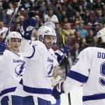 Tampa Bay Lightning right winger Teddy Purcell, center, celebrates with teammates Steve Downie, right, and Vincent Lecavalier, left, after scoring a goal against the Phoenix Coyotes in the first period of an NHL hockey game on Saturday, Jan. 21, 2012, in Glendale, Ariz. (AP Photo/Paul Connors)