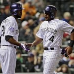 Colorado Rockies' Chris Nelson (4) is congratulated by teammate Dexter Fowler (24) after scoring from third on a fly ball by Colorado Rockies' Jhoulys Chacin in the fifth inning of a baseball game against the Arizona Diamondbacks at Coors Field in Denver, Friday, April 19, 2013. (AP Photo/Brennan Linsley)