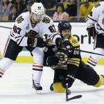 Chicago Blackhawks center Michael Frolik (67), of the Czech Republic, and Boston Bruins right wing Nathan Horton (18) scrap for the puck during the second period in Game 3 of the NHL hockey Stanley Cup Finals in Boston, Monday, June 17, 2013. (AP Photo/Elise Amendola)