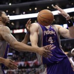 Phoenix Suns center Marcin Gortat, right, gets a rebound as teammate Markieff Morris, left, watches during the first half of an NBA basketball game against the Los Angeles Clippers in Los Angeles, Thursday, March 15, 2012. (AP Photo/Jae C. Hong)